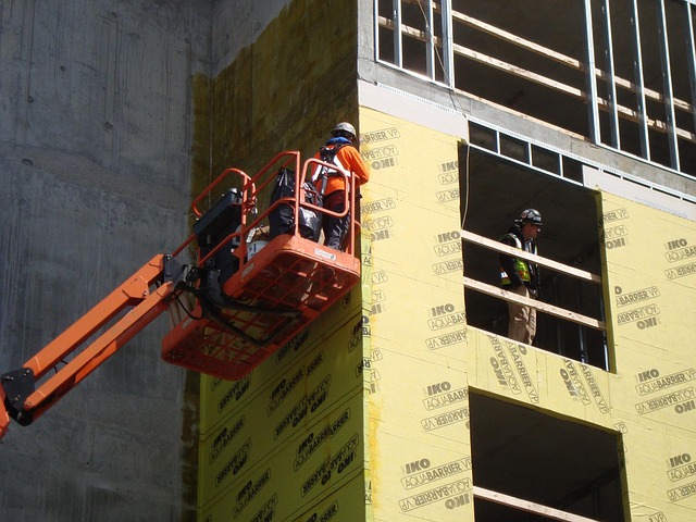 Boom lift basket raised beside a building