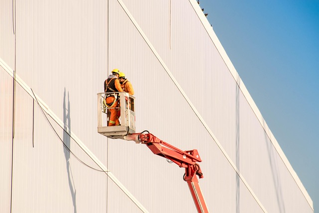 Two workers in a cherry picker basket